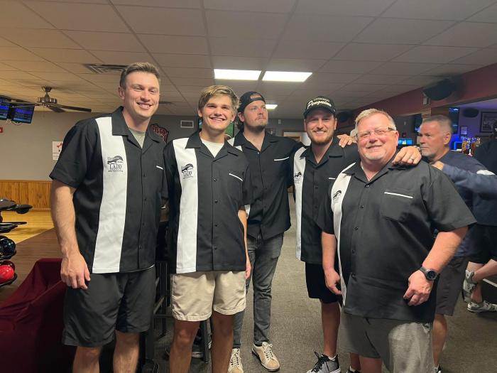 Men from LADD Agency wearing classic black bowling shirts with white side panels and custom embroidered chest logos
