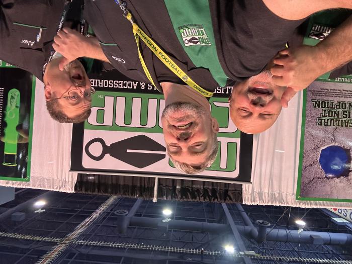 Professional team wearing custom black and green embroidered logo bowling shirts for a corporate trade show and branding event