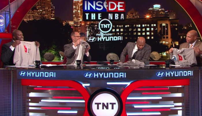 Inside the NBA hosts Shaq and Charles Barkley holding up custom promotional shirts showcasing corporate branding potential
