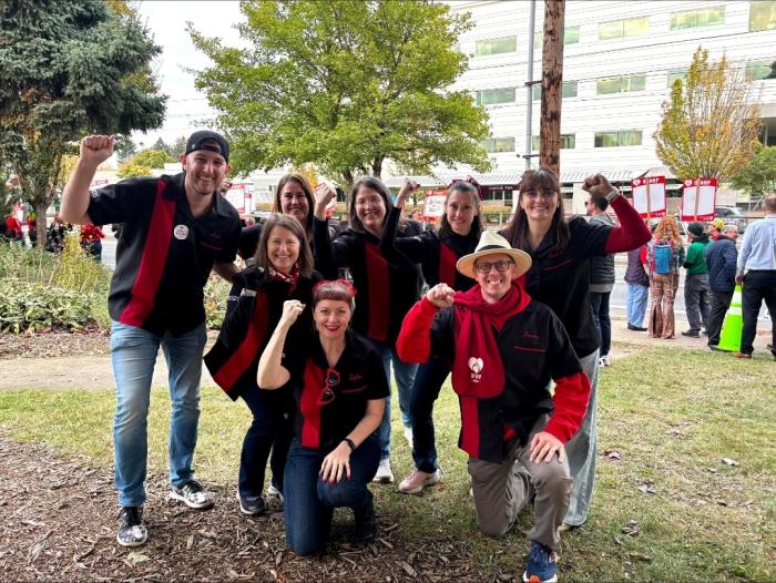 A diverse group wearing black and red retro style bowling shirts for a community team building event and strike rally