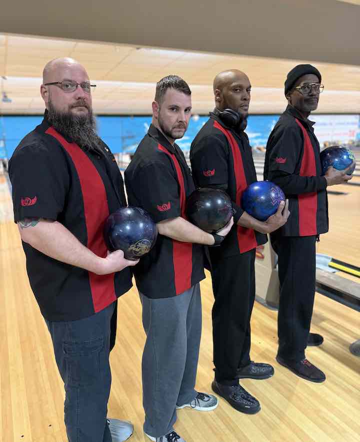 Four men wearing custom retro men's bowling shirts on a lane